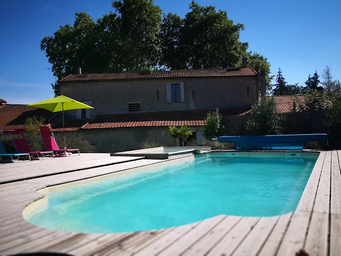 Piscine extérieure du Château Puygrenier avec terrasse en bois et transats
